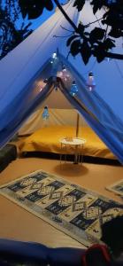 a tent with a table in the middle of it at Glamping Cisnadioara in Cisnădioara