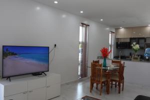 a living room with a tv and a table with chairs at Ocean Pearl - Getaway Holiday home in Long Bay Hills