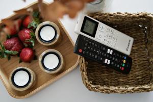 a remote control sitting on a table next to a basket of strawberries at Magic Apartments - Bulwary 3 in Oświęcim