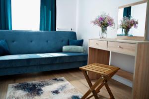 a living room with a blue couch and a table at Magic Apartments - Bulwary 3 in Oświęcim