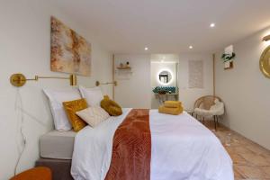 ein Schlafzimmer mit einem großen weißen Bett und einem Stuhl in der Unterkunft La Parenthèse, chambres d'hôtes in Rochegude