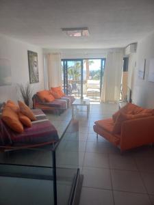 a living room with couches and a view of a patio at Club Del Mar No.8 in Puerto del Carmen