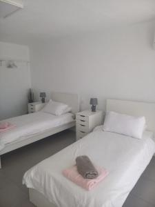 ein Zimmer mit 2 Betten mit Hut darauf in der Unterkunft Club Del Mar No.8 in Puerto del Carmen