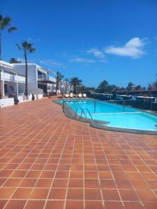 an empty swimming pool on a red brick sidewalk at Club Del Mar No.8 in Puerto del Carmen