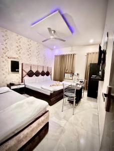 um quarto com 2 camas, uma mesa e uma cadeira em swaran House em Amritsar