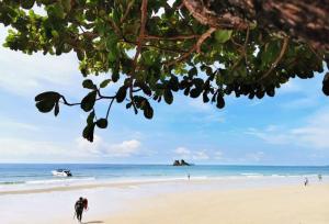 a beach with people walking on the sand and the ocean at Avatara B condominium B54 in Ban Tha Fat