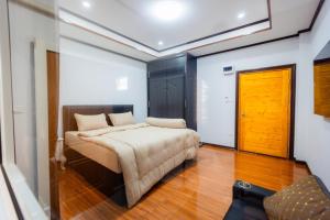 a bedroom with a bed and a wooden door at BanWongdee in Ban Pa Ton