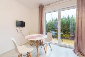 Nadmorski Apartament V by Holiday&Sun في جيبوفو: غرفة مع طاولة وكراسي ونافذة