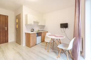 Nadmorski Apartament V by Holiday&Sun في جيبوفو: مطبخ صغير مع طاولة وكراسي في الغرفة