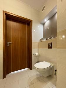 a bathroom with a toilet and a wooden door at Apartment Platinum in Międzyzdroje