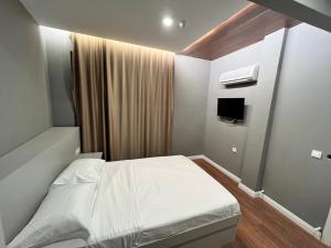 Cette petite chambre comprend un lit blanc et une télévision. dans l'établissement GÖKOTTA HOTEL, à Istanbul