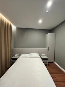 - une chambre avec un grand lit blanc et 2 tables dans l'établissement GÖKOTTA HOTEL, à Istanbul