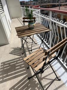 a wooden bench on a balcony with a potted plant at Alysia House in Naples