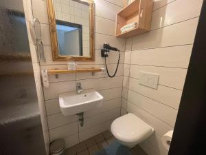 een badkamer met een toilet, een wastafel en een spiegel bij KobyApartment Souterrain in Herford