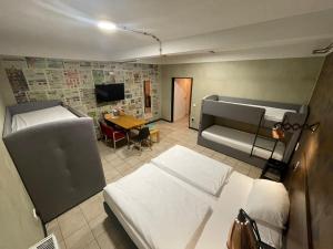 een slaapkamer met 2 bedden, een bureau en een tafel bij KobyApartment Souterrain in Herford