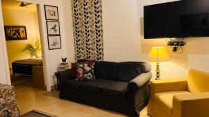 蘭斯多沃內的住宿－The Sunshine Room, Deluxe room in The Umri Lansdowne，带沙发和电视的客厅