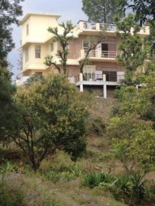 a large building on top of a hill with trees at The Sunshine Room, Deluxe room in The Umri Lansdowne in Lansdowne