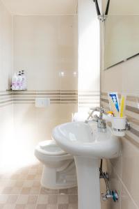 La salle de bains blanche est pourvue de toilettes et d'un lavabo. dans l'établissement Dashim Guest House, à Gunsan