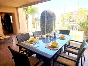 a dining room table with chairs and a blue table and chairsktop at Espliego Pool View Apartment in Torre-Pacheco