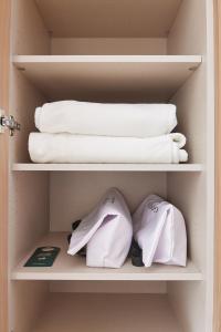 a closet with towels and towels on a shelf at Georg Ots Spa Hotel in Kuressaare