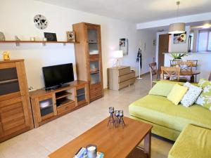 a living room with a couch and a television at Espliego Pool View Apartment in Torre-Pacheco