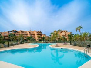 a swimming pool at a resort with palm trees and condos at Espliego Pool View Apartment in Torre-Pacheco