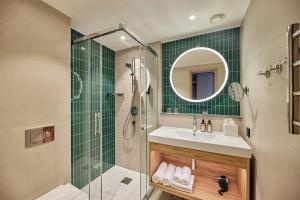 a bathroom with a shower and a sink and a mirror at Georg Ots Spa Hotel in Kuressaare