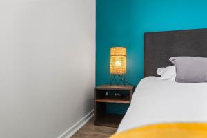 - une chambre avec un lit et une lampe sur une table de chevet dans l'établissement Terraces of Bonlieu - the nest, à Annecy
