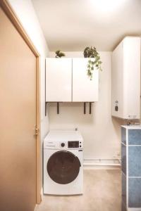 a kitchen with a washing machine in a room at Le Cocon Manceau in Le Mans