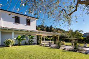 a white house with a lawn and trees at Villa Solià - Villa indipendente con Piscina e Giardino in Campofelice di Roccella +40 photos