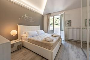 Un dormitorio con una gran cama blanca y una ventana. en Villa Solià, en Campofelice di Roccella