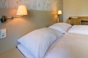 2 Betten in einem Hotelzimmer mit weißen Kissen in der Unterkunft Hotel Srní in Srní