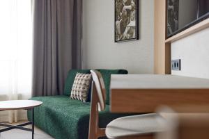 un soggiorno con divano verde e tavolo di Georg Ots Spa Hotel a Kuressaare