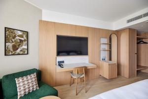 a hotel room with a desk and a green chair at Georg Ots Spa Hotel in Kuressaare