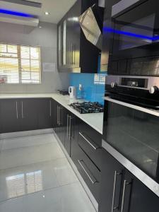 a kitchen with black cabinets and a stove top oven at Icebolethu Guest House in Standerton