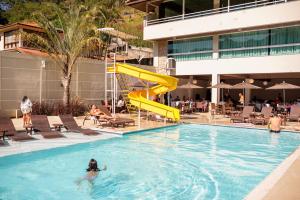 a pool with a yellow slide in a hotel at Hotel Vila Verde in Nova Friburgo
