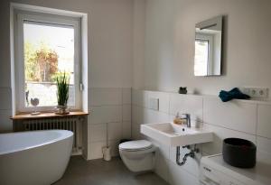 łazienka z wanną, toaletą i umywalką w obiekcie Schneiders Ferienwohnungen w mieście Braunshausen