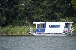 a blue and white boat on the water at Kuhnle-Tours Hafendorf Müritz in Rechlin