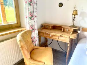 een slaapkamer met een bureau en een stoel naast een raam bij Villa Edyta Ellmau in Ellmau