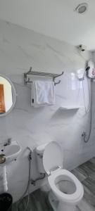 Casa Victoria Pension House- Star Challenger في Somosomo: حمام ابيض مع مرحاض ومغسلة