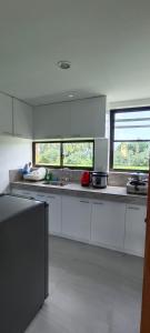 een grote keuken met witte werkbladen en ramen bij Casa Victoria Pension House- Star Challenger in Somosomo