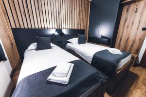 twee bedden in een kleine kamer met twee handdoeken bij Vidikovac-Berane in Berane