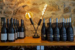 a row of wine bottles on a shelf with a microphone at La Parenthèse, chambres d'hôtes in Rochegude