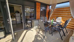 a patio with a table and chairs and a kitchen at CHARTA mobile home Roko in Pirovac