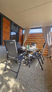 a patio with a table and chairs on a balcony at CHARTA mobile home Roko in Pirovac