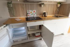 a kitchen with white cabinets and a sink and an open refrigerator at Apartment Blanco - Vina Mar III in La Mata