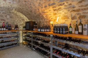 una bodega llena de botellas de vino en La Parenthèse, chambres d'hôtes en Rochegude
