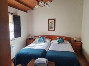 um quarto com 2 camas com lençóis azuis e brancos em Complejo turístico Las Mimosas del Nalon, LOS NOVALES em San Juan de la Arena