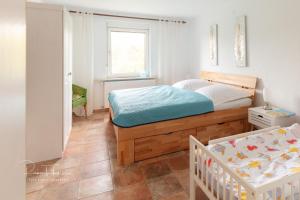 een slaapkamer met een bed en een wieg erin bij Ferienhaus Specht in Schotten