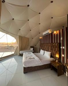 um quarto com uma cama grande numa tenda em Sunset colors camp em Wadi Rum